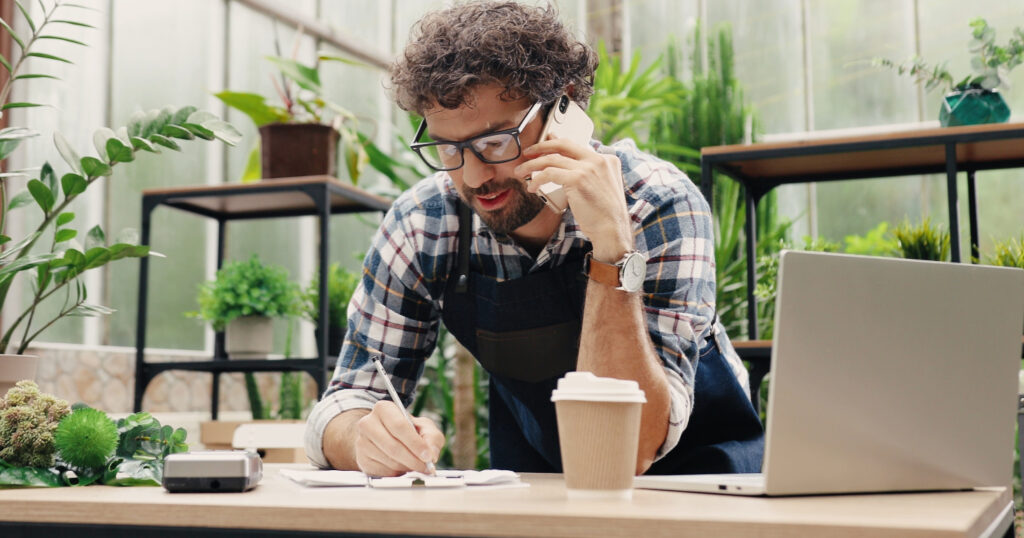 A person on the phone and taking notes