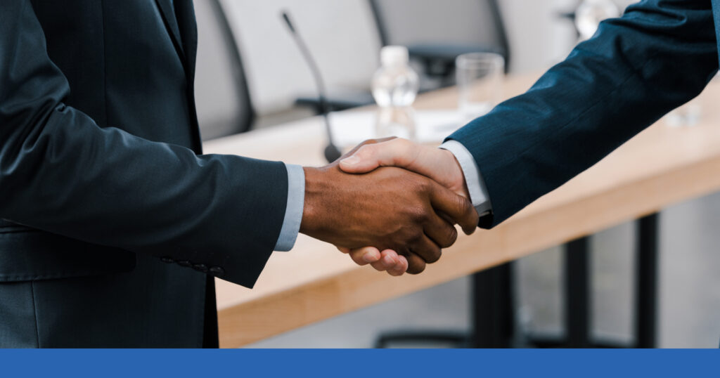 Two professionally dress people shaking hands
