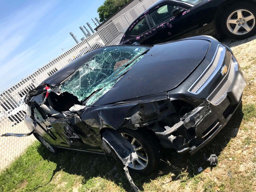 A car with significant passenger-side damage from a truck accident