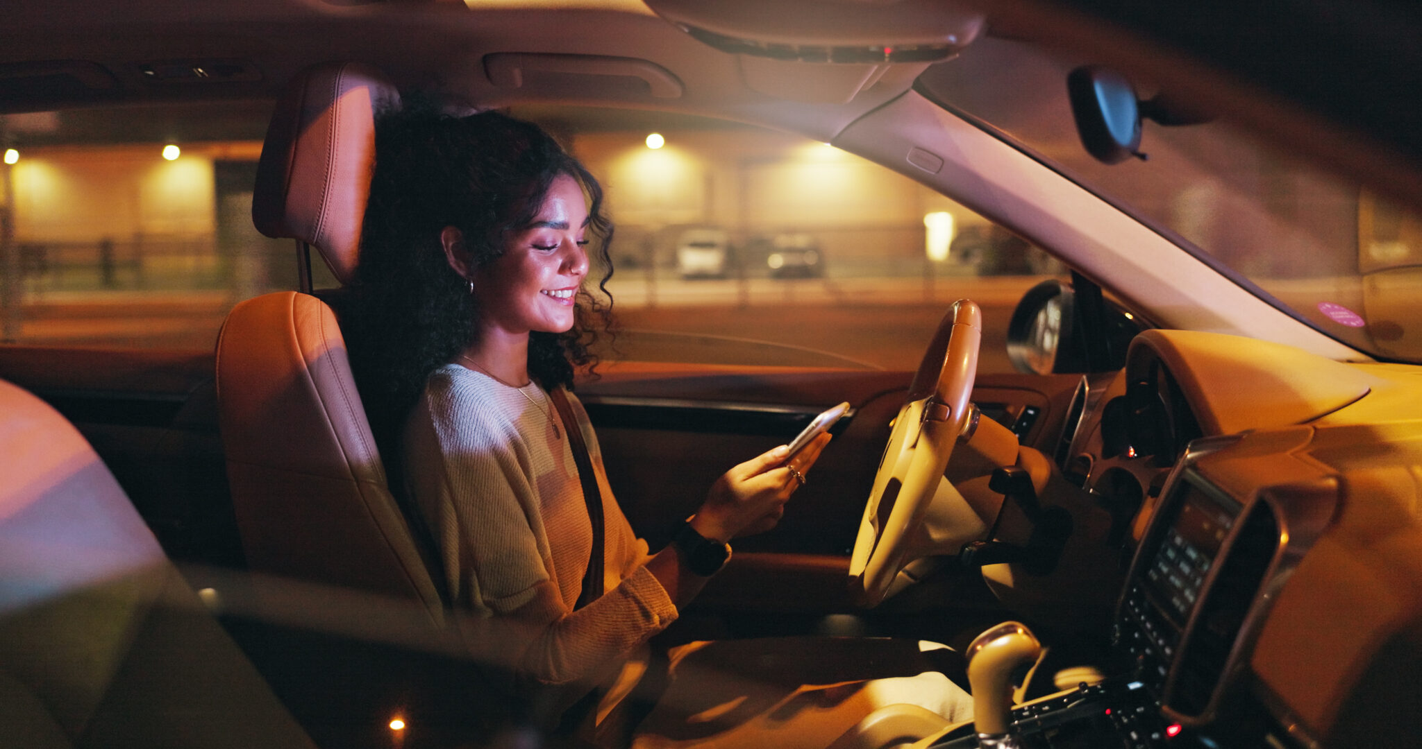 Business, night and phone with happy woman in car on city street for commute to destination. App, ride and smile with professional employee in vehicle for directions of drive in dark urban location.