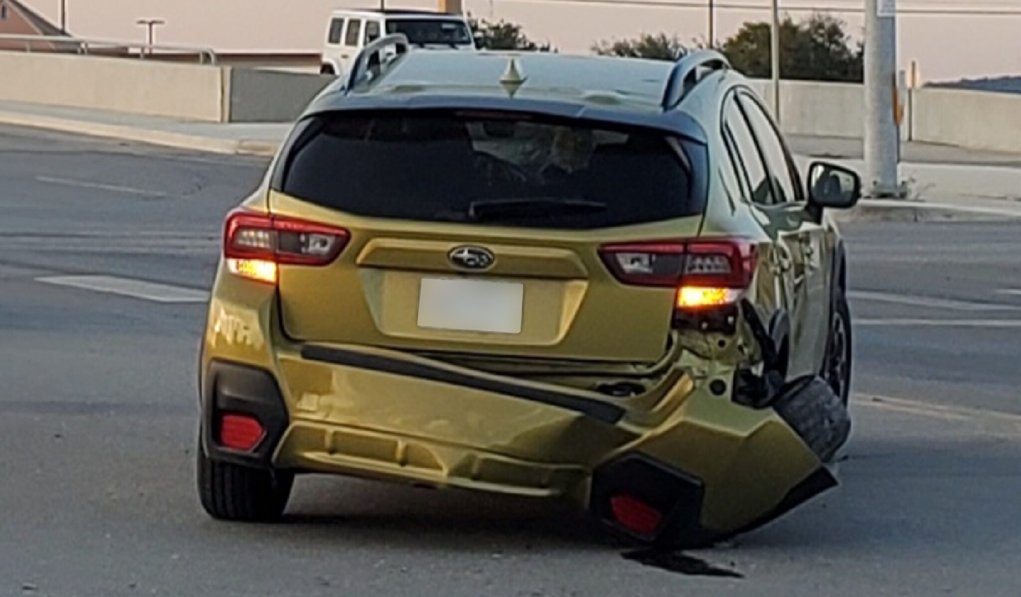 A yellow car with passenger side rear end damage after a car accident