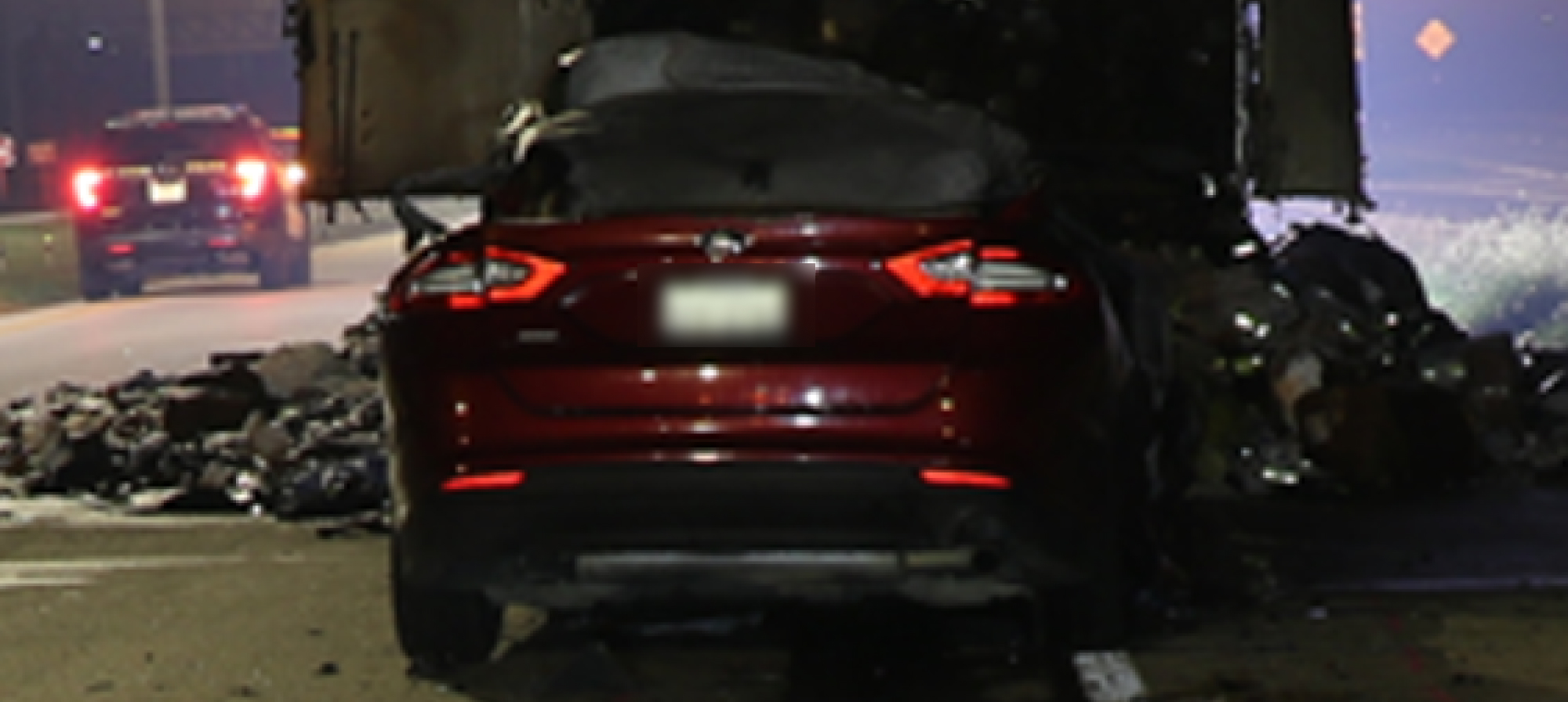 Rear view of a car that crashed into a tractor trailer