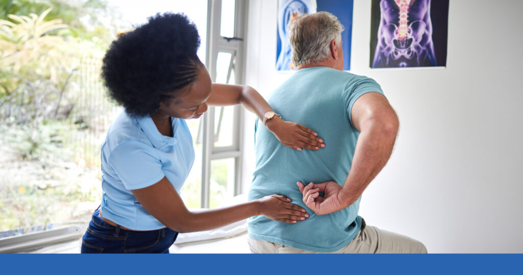 A therapist works with a man on his injured back