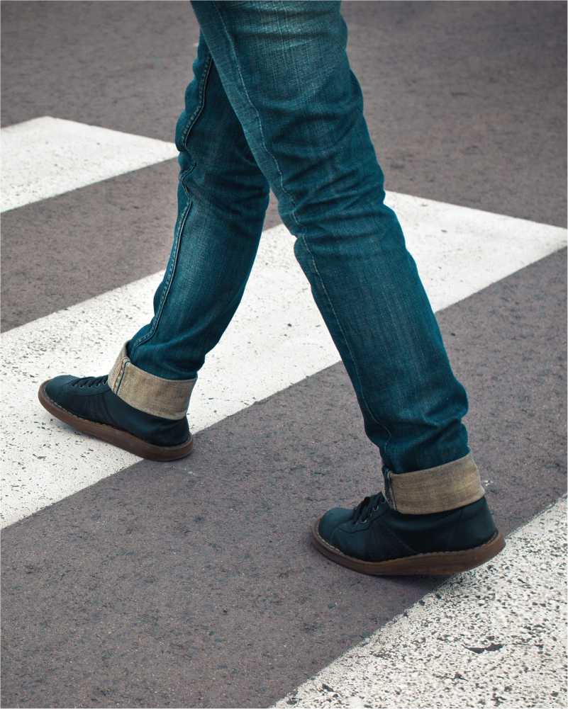 A pedestrian walks through a crosswalk