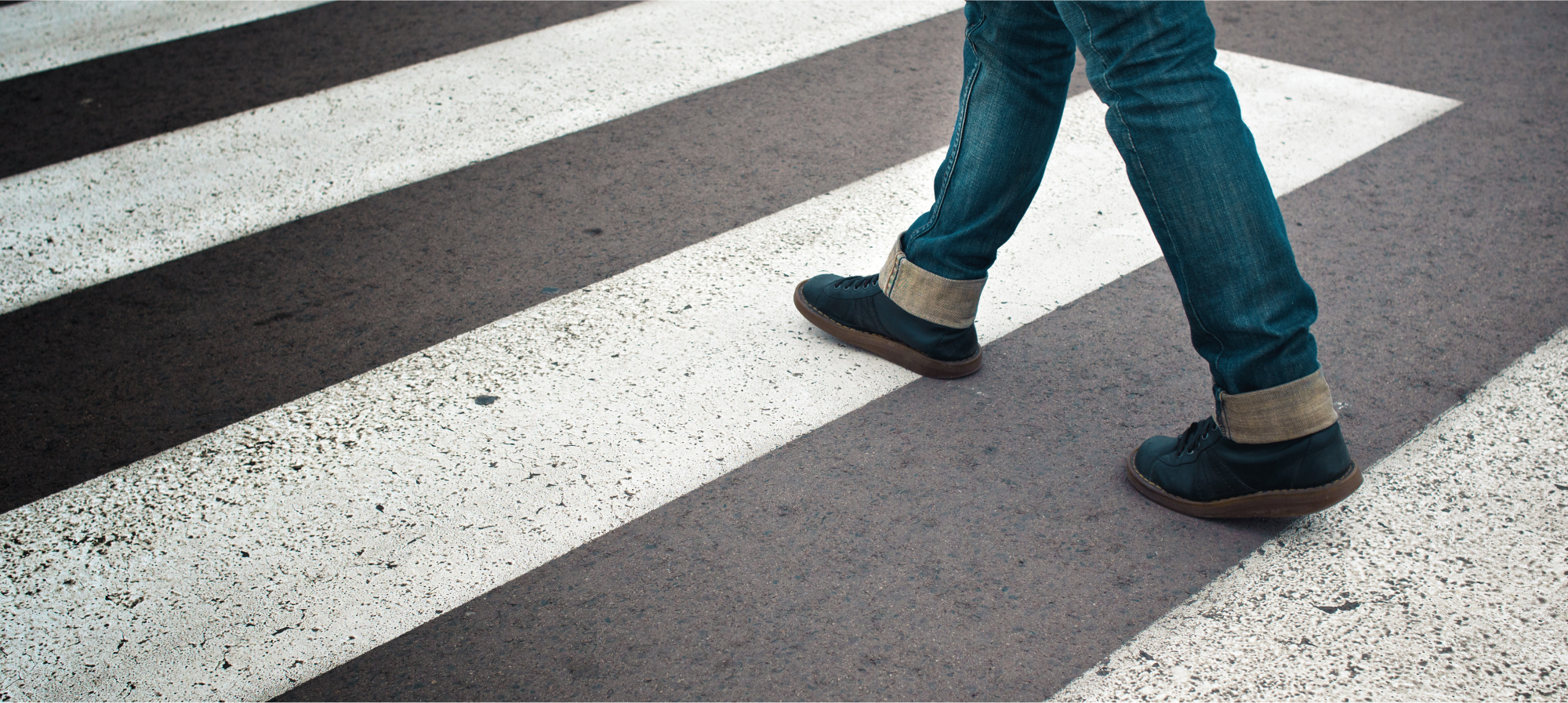 A pedestrian walks through a crosswalk