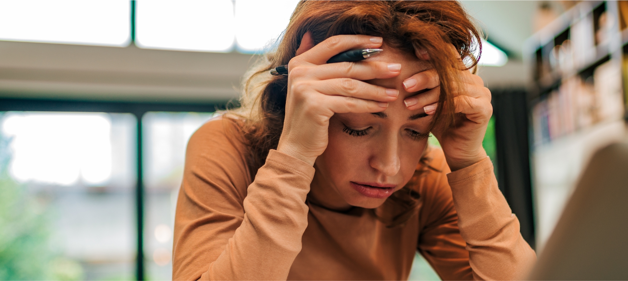 a woman holding her head with her hand