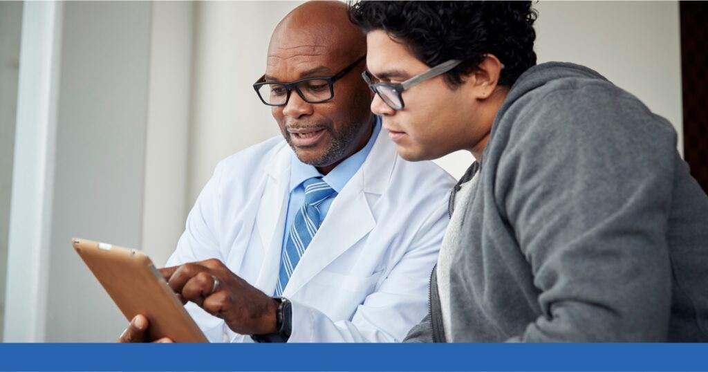a man looking at a tablet with a doctor
