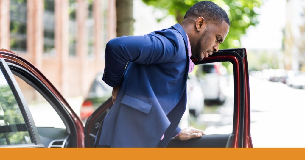 a man walking on the street experiencing back pain after a car accident