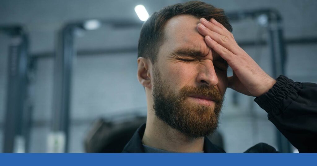 a man holding his head showing pain from a TBI