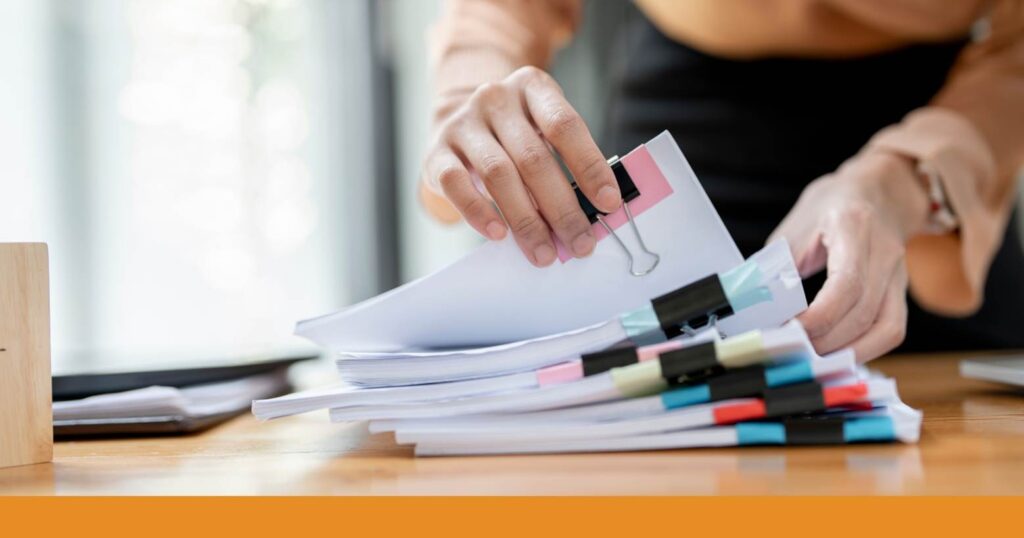 a person going through an organized stack of paperwork