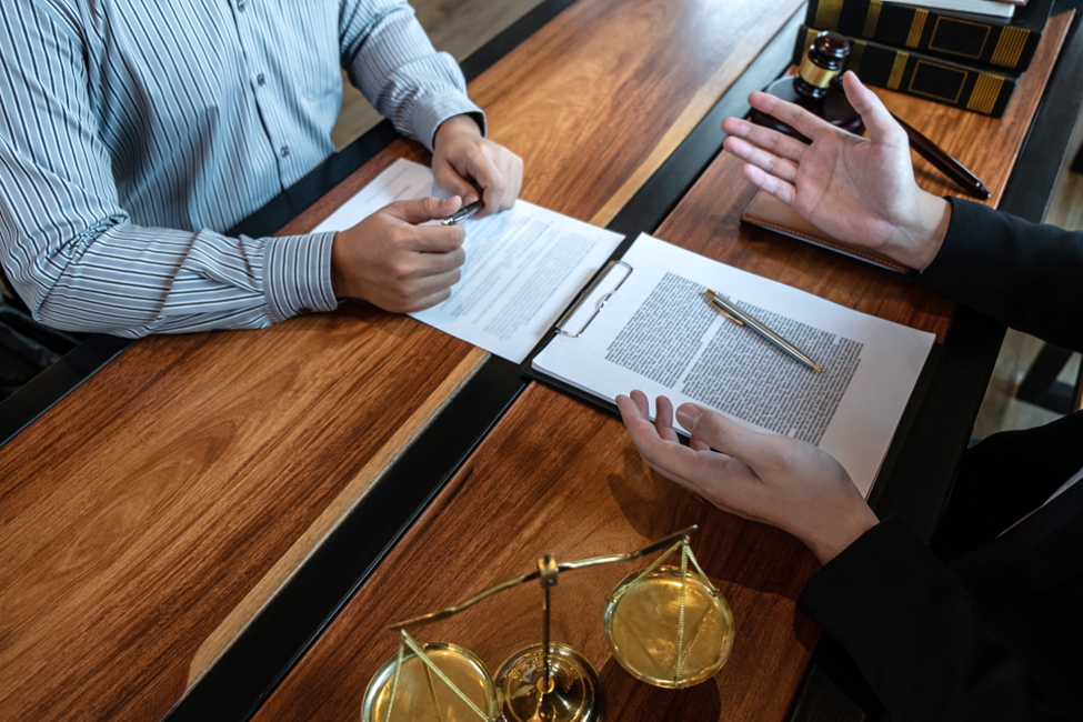 Two people discussing a comparative negligence case with paperwork in front of them