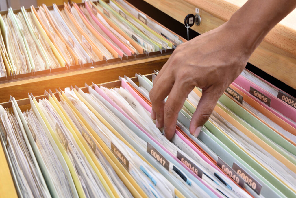 Hand of the employee search Financial documents stored in filing cabinets.