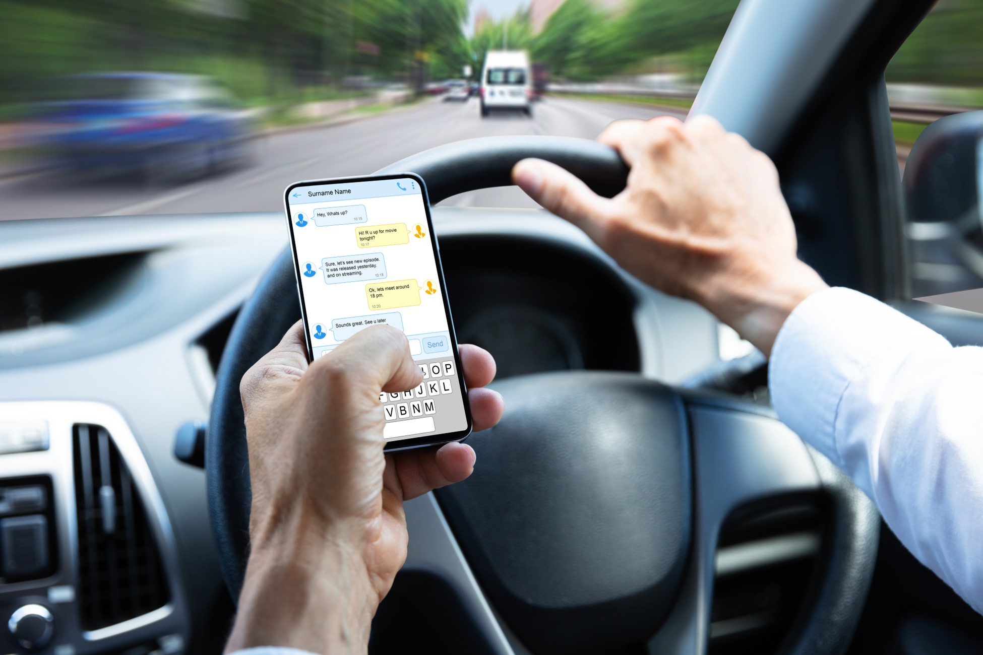 Driver texting on smartphone while operating vehicle on Texas roadway, illustrating distracted driving