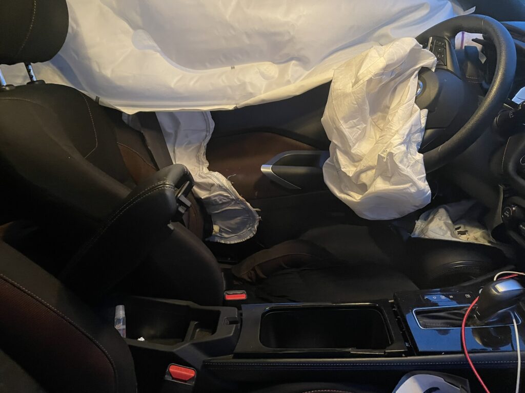 Interior del vehículo de la clienta tras el accidente, en el que se observan los airbags del lado del conductor, de la puerta y de la ventanilla totalmente desplegados, lo que probablemente le salvó la vida
