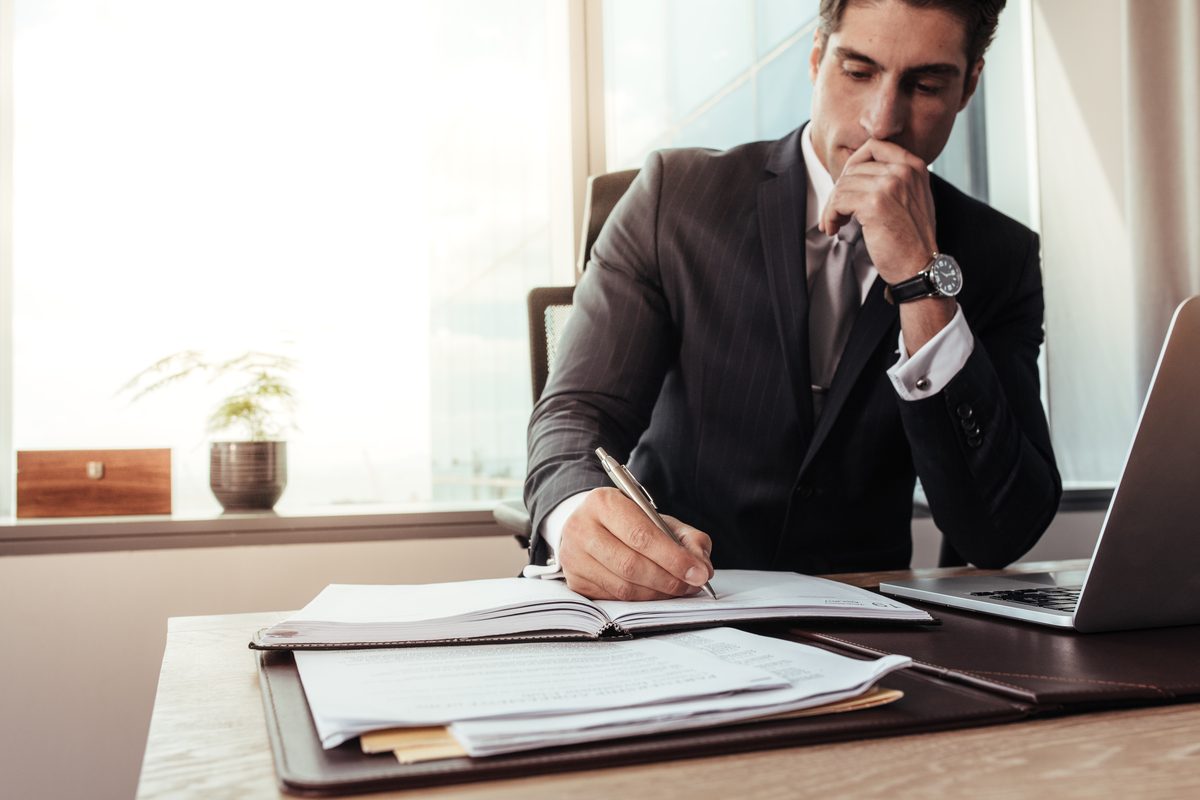 Attorney in a suit reviewing case documents at a desk, building a San Antonio car accident claim