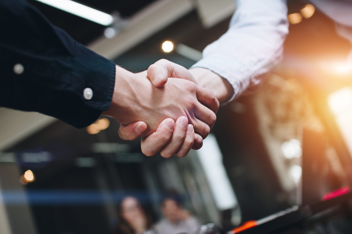 Close-up of two people shaking hands, representing the settlement Crosley Law secured for the client