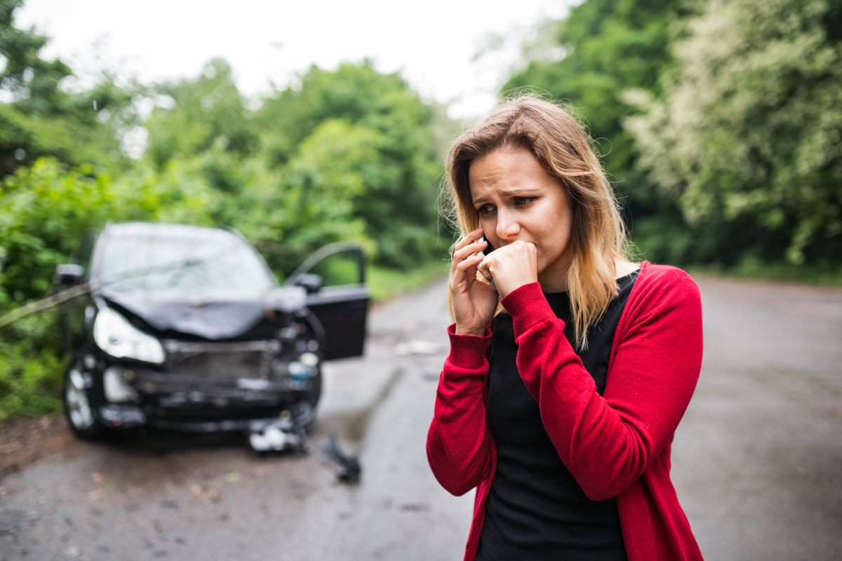 Upset woman calling for help beside her damaged car after a Texas accident