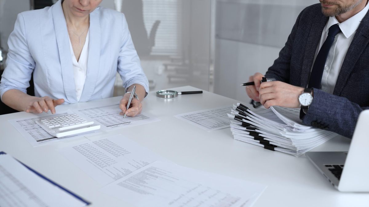 Insurance professionals reviewing medical bills and paperwork with a calculator
