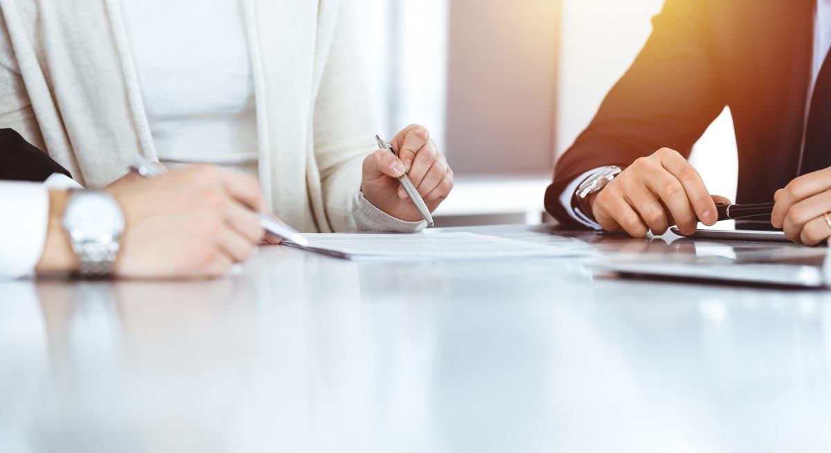 A lawyer and client review and sign documents at a table during a car accident case consultation