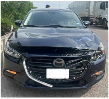 Dark sedan with a crumpled hood and broken grille after a driver rolled through a stop sign into its path